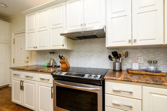 a kitchen with kitchen island granite countertop white cabinets and a stainless steel appliances
