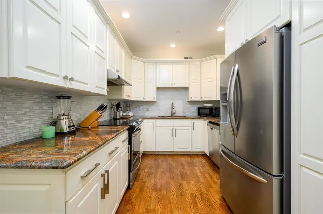 a kitchen with a refrigerator a sink and cabinets
