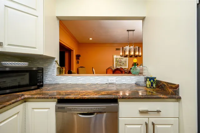 a kitchen with stainless steel appliances granite countertop a sink and a microwave