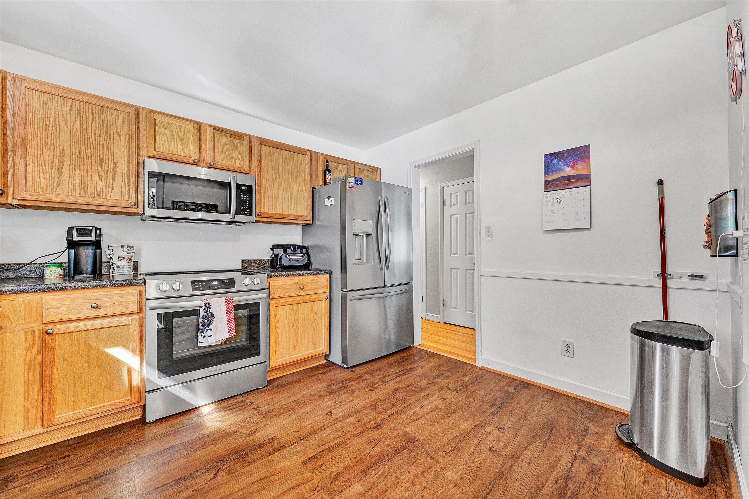 6836 Trevilian Road Roanoke, VA 24019 - Photo 17 of 47 a kitchen with a refrigerator stainless steel appliances wooden floor and cabinets