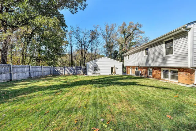 a view of yard with swimming pool and wooden fence