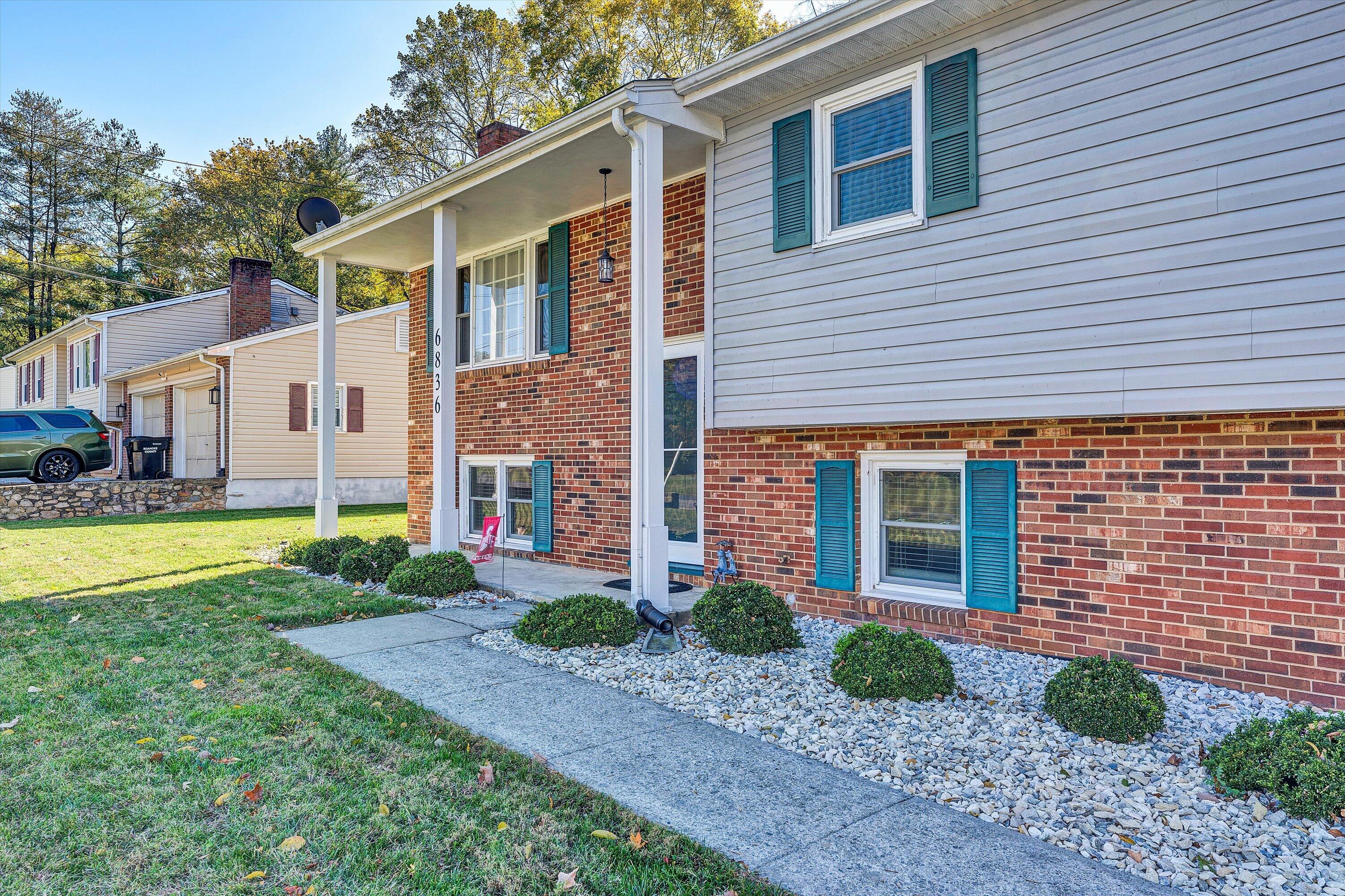6836 Trevilian Road Roanoke, VA 24019 - Photo 5 of 47 a view of a white house next to a yard with potted plants