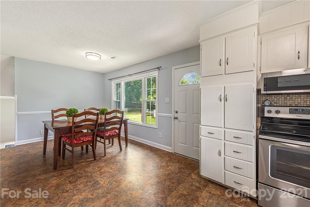 2531 Milton Road Charlotte, NC 28215 - Photo 8 of 19 a kitchen with white cabinets and stainless steel appliances