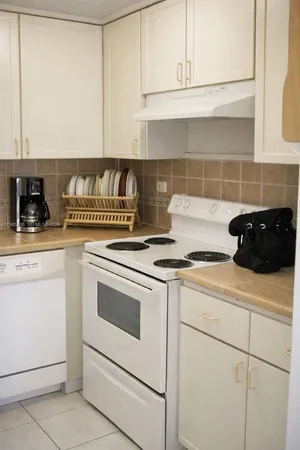 a kitchen with granite countertop cabinets and white appliances