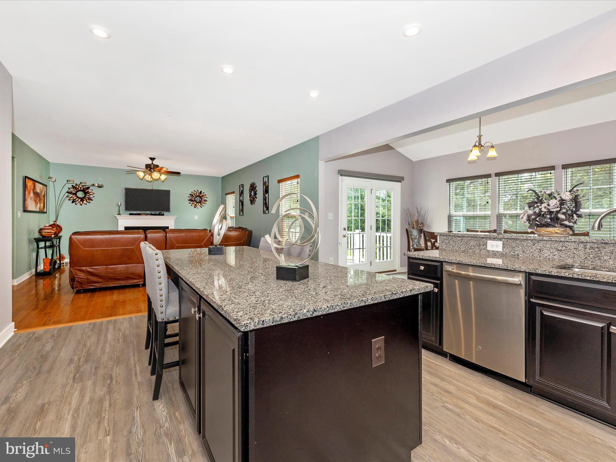 2004 Quandary Drive Frederick, MD 21702 - Photo 12 of 47 a kitchen with stainless steel appliances granite countertop a stove top oven a sink dishwasher a dining table and chairs with wooden floor