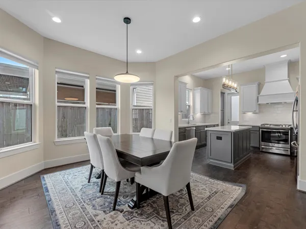a dining room with furniture a chandelier and wooden floor