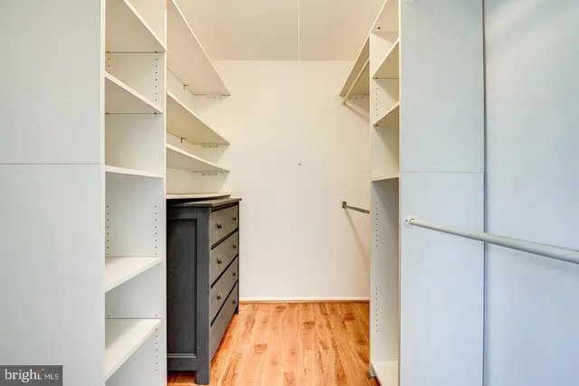 a view of walk in closet with empty racks