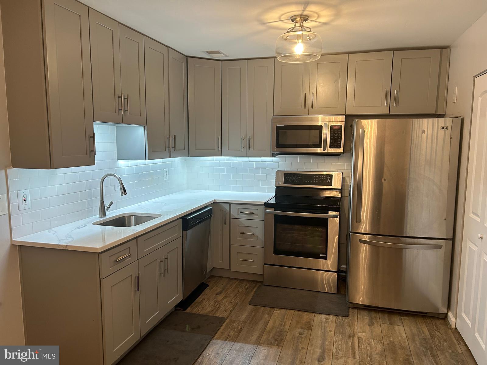 1805 Westwind Way, Unit 55 McLean, VA 22102 - Photo 4 of 30 a kitchen with kitchen island granite countertop a sink cabinets and stainless steel appliances