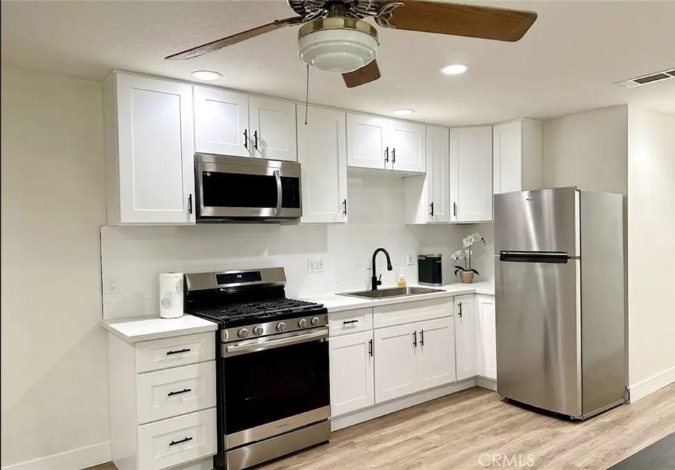 425 Lewis Place Placentia, CA 92870 - Photo 12 of 18 a kitchen with a refrigerator stove and white cabinets