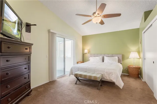 a bedroom with a bed and a flat tv screen on dresser