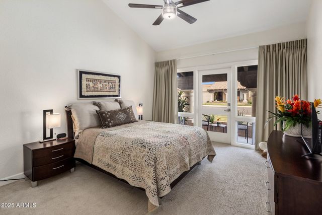 a bedroom with a bed table and a flat screen tv