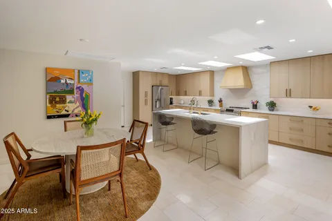 a kitchen with a stove a sink a dining table and chairs