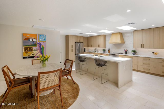 a kitchen with a stove a sink a dining table and chairs