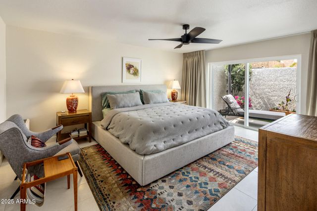 a bedroom with a bed a lamp and a large window