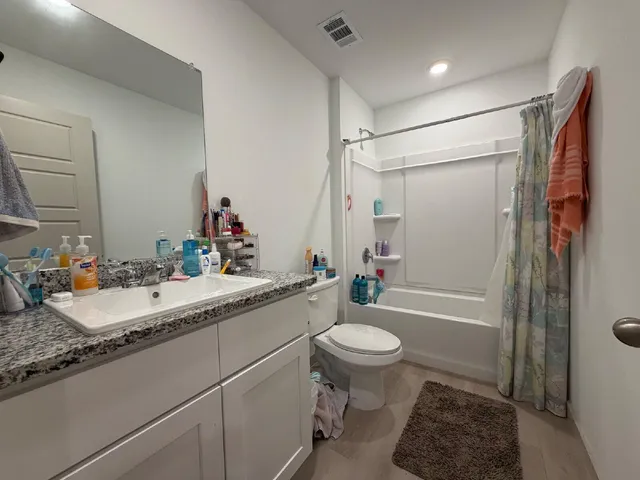 a bathroom with a granite countertop sink toilet and shower