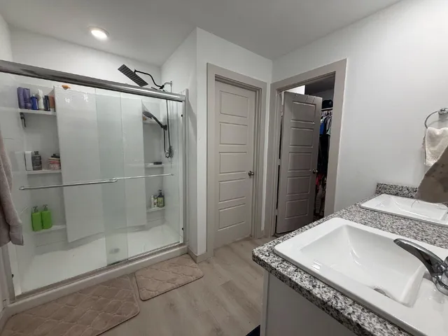 a bathroom with a granite countertop sink a shower and a mirror
