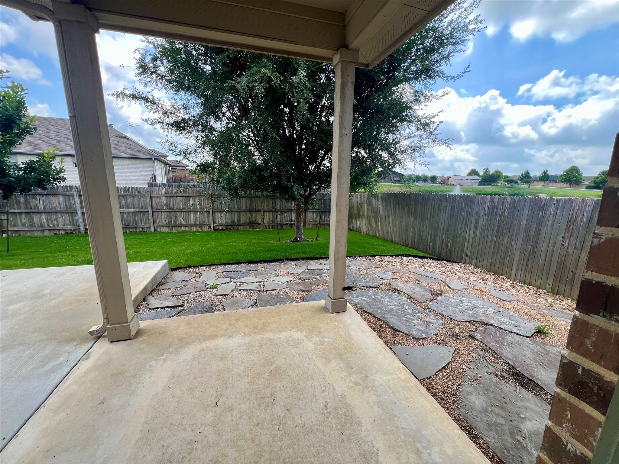 104 Moravia Road Georgetown, TX 78626 - Photo 34 of 36 Enjoy outdoor moments on the concrete patio and flagstone-laid area, gazing upon the serene pond.