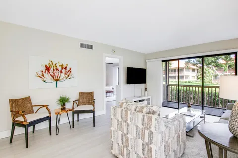 a living room with furniture a flat screen tv and a large window