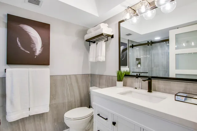 a bathroom with a sink a toilet and mirror