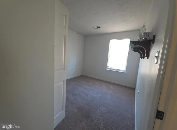 a view of empty room with windows and closet