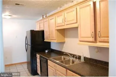 a kitchen with a sink a refrigerator and a cabinets