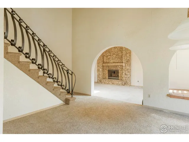 a view of an empty room with a fireplace and a window