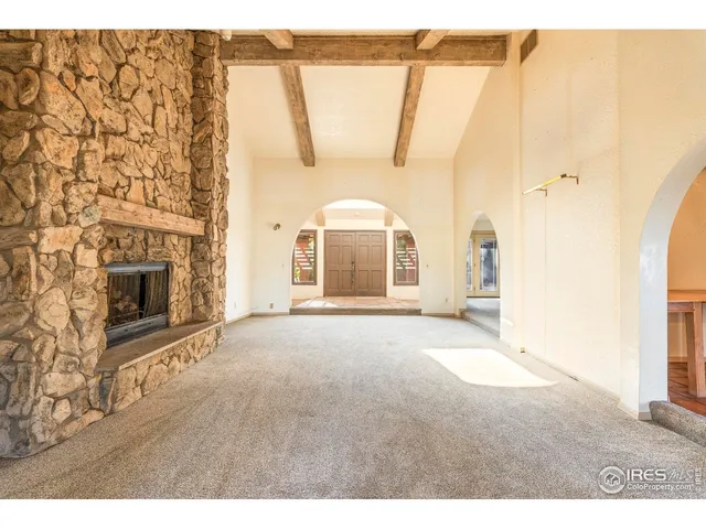 a view of an empty room with a fireplace and a window