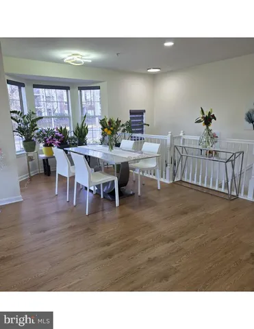a living room with furniture a dining table and a potted plant