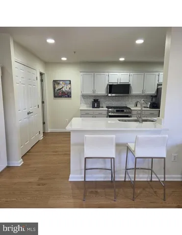 a living room with stainless steel appliances kitchen island granite countertop a sink a stove a microwave a dining table and chairs