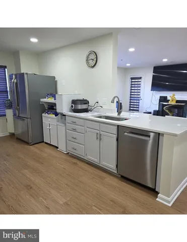 a kitchen with stainless steel appliances kitchen island granite countertop a sink and cabinets