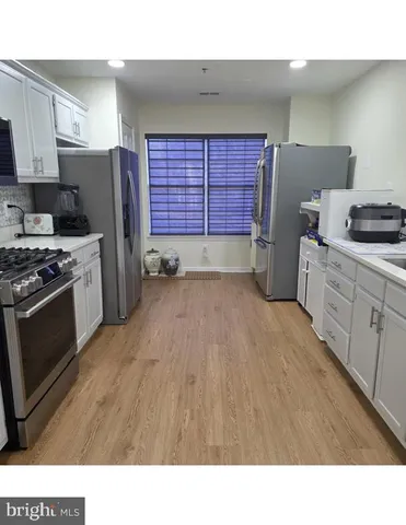 a kitchen with a refrigerator and a stove top oven