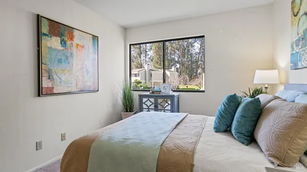 a bedroom with a bed and a painting on the wall