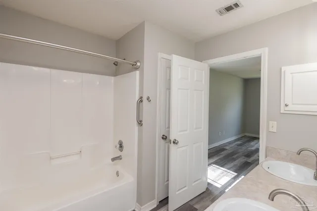 a bathroom with a granite countertop bathtub shower sink and toilet