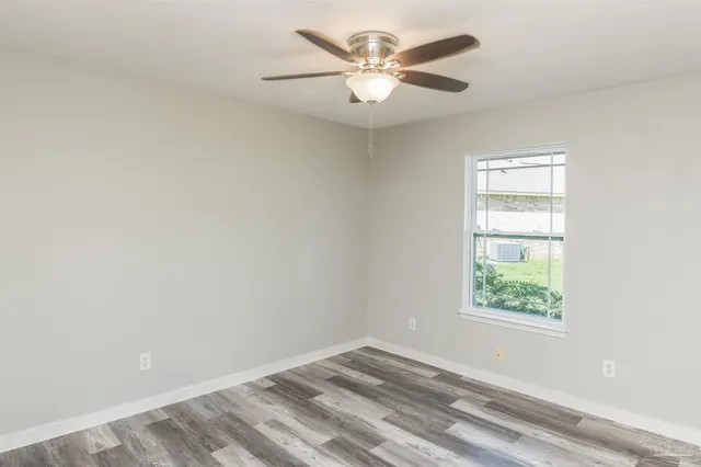 an empty room with a window and a fan