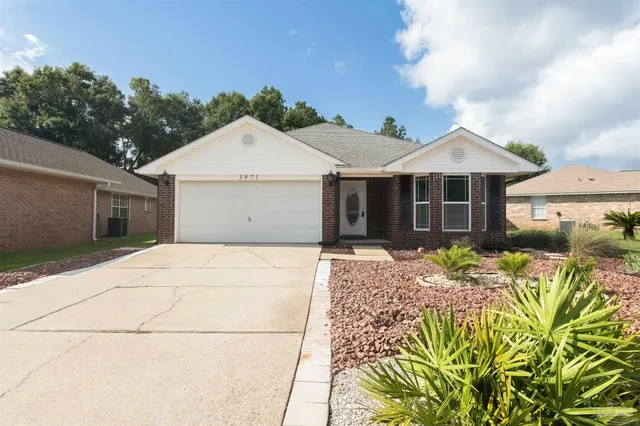 a view of a house with a yard and potted plants