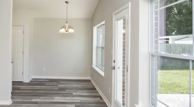 a view of a room with wooden floor and windows