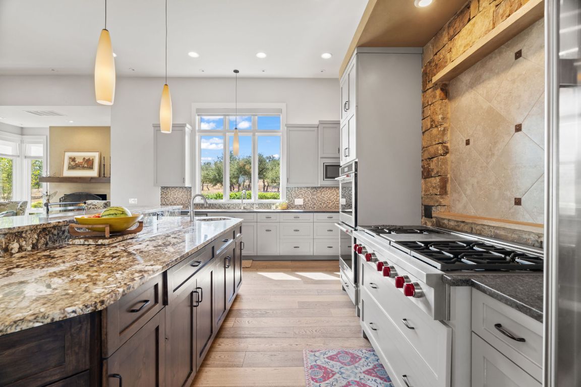 11400 Crumley Ranch Road Austin, TX 78738 - Photo 13 of 39 a kitchen with stainless steel appliances granite countertop a stove a sink and a refrigerator