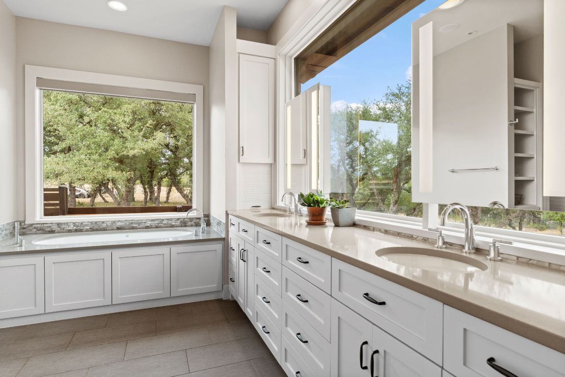 11400 Crumley Ranch Road Austin, TX 78738 - Photo 21 of 39 a bathroom with a granite countertop sink and a large mirror