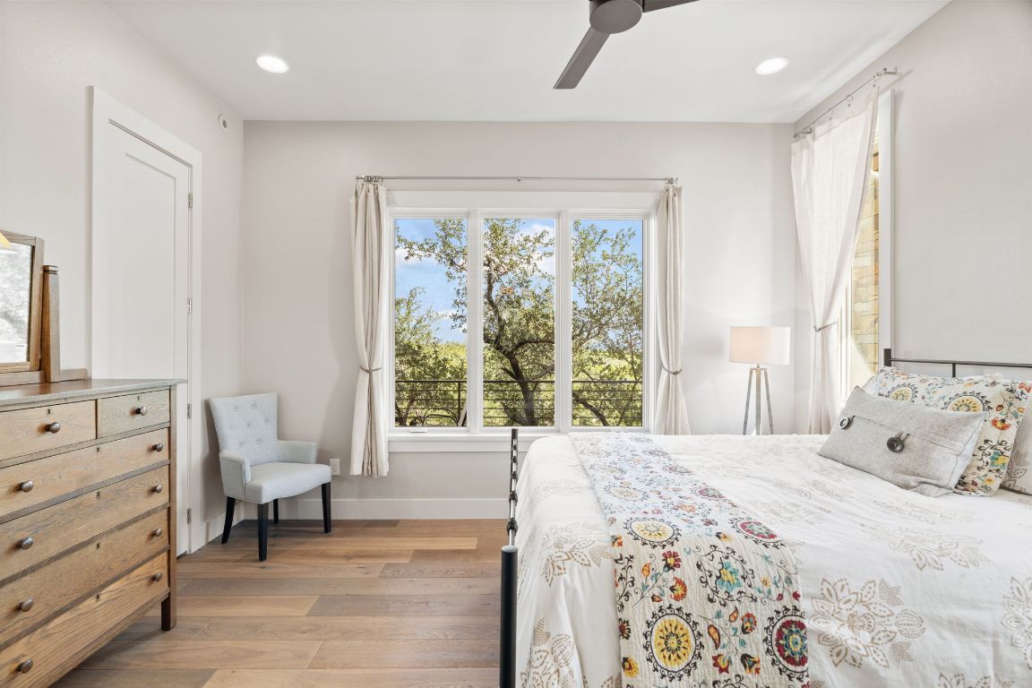 11400 Crumley Ranch Road Austin, TX 78738 - Photo 27 of 39 a bedroom with a bed and a large window