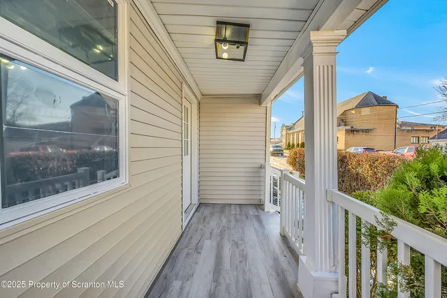 a view of a hallway with wooden floor and windows