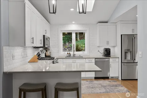 a kitchen with a sink a refrigerator and chairs