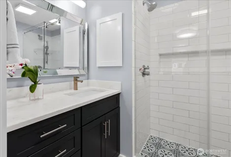 a bathroom with a sink a mirror and shower