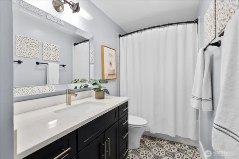 a bathroom with a sink a toilet and shower curtain
