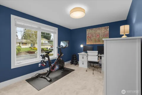 a view of a workspace with furniture and a window
