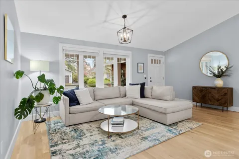 a living room with furniture a chandelier and a rug
