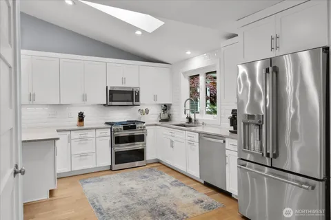 a kitchen with granite countertop a refrigerator stove and microwave