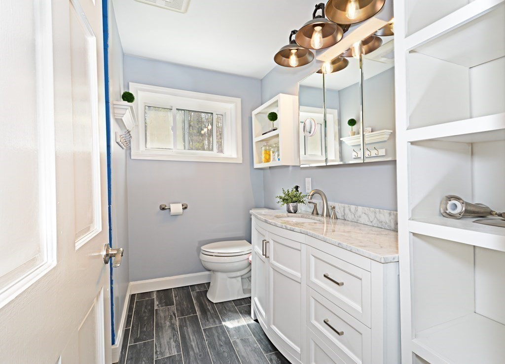 107 Causeway Street Hudson, MA 01749 - Photo 15 of 21 a bathroom with a granite countertop sink mirror vanity and toilet