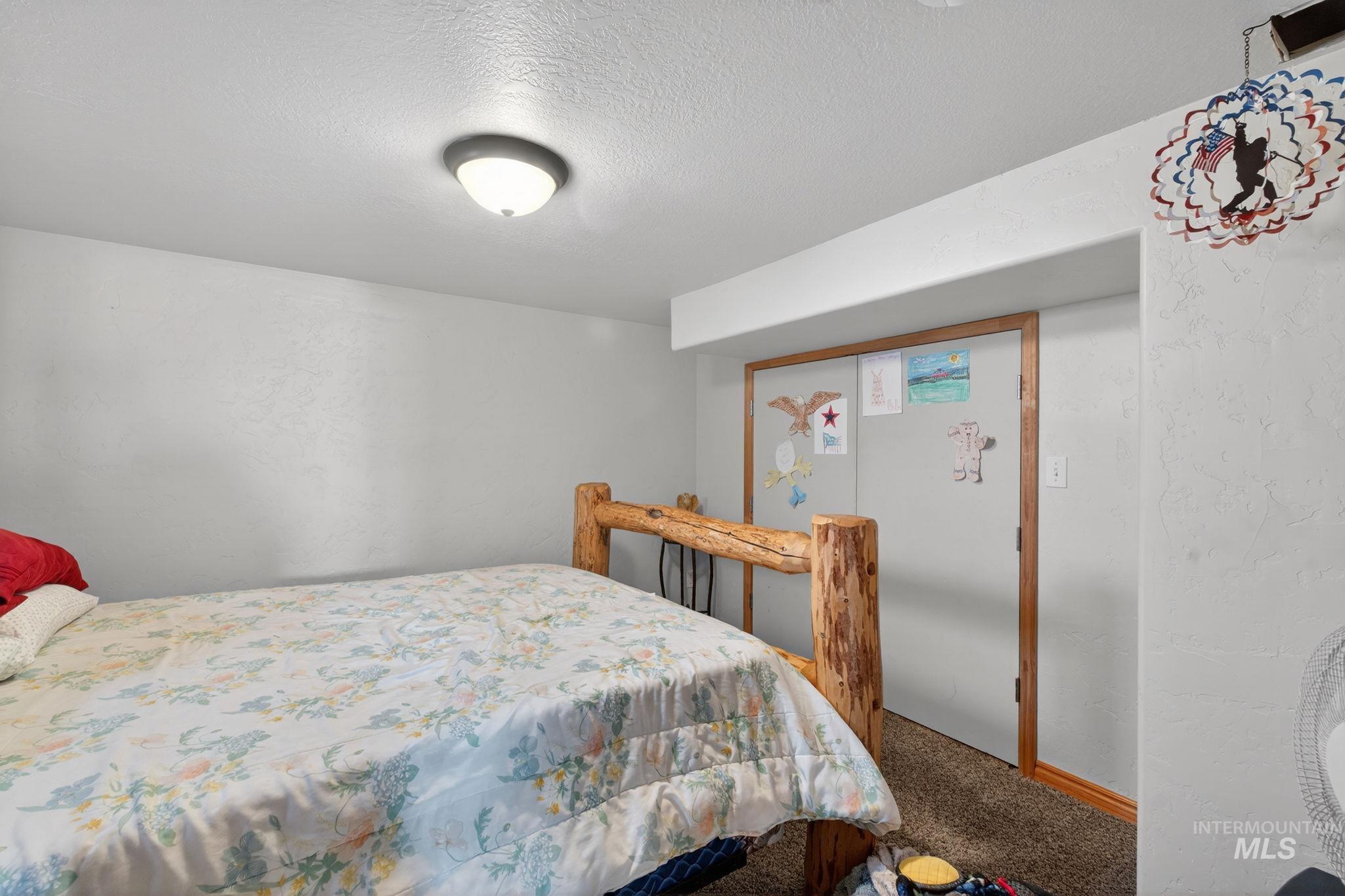 49 South 4th Street West Preston, ID 83263 - Photo 15 of 48 Carpeted bedroom featuring a textured ceiling and a textured wall