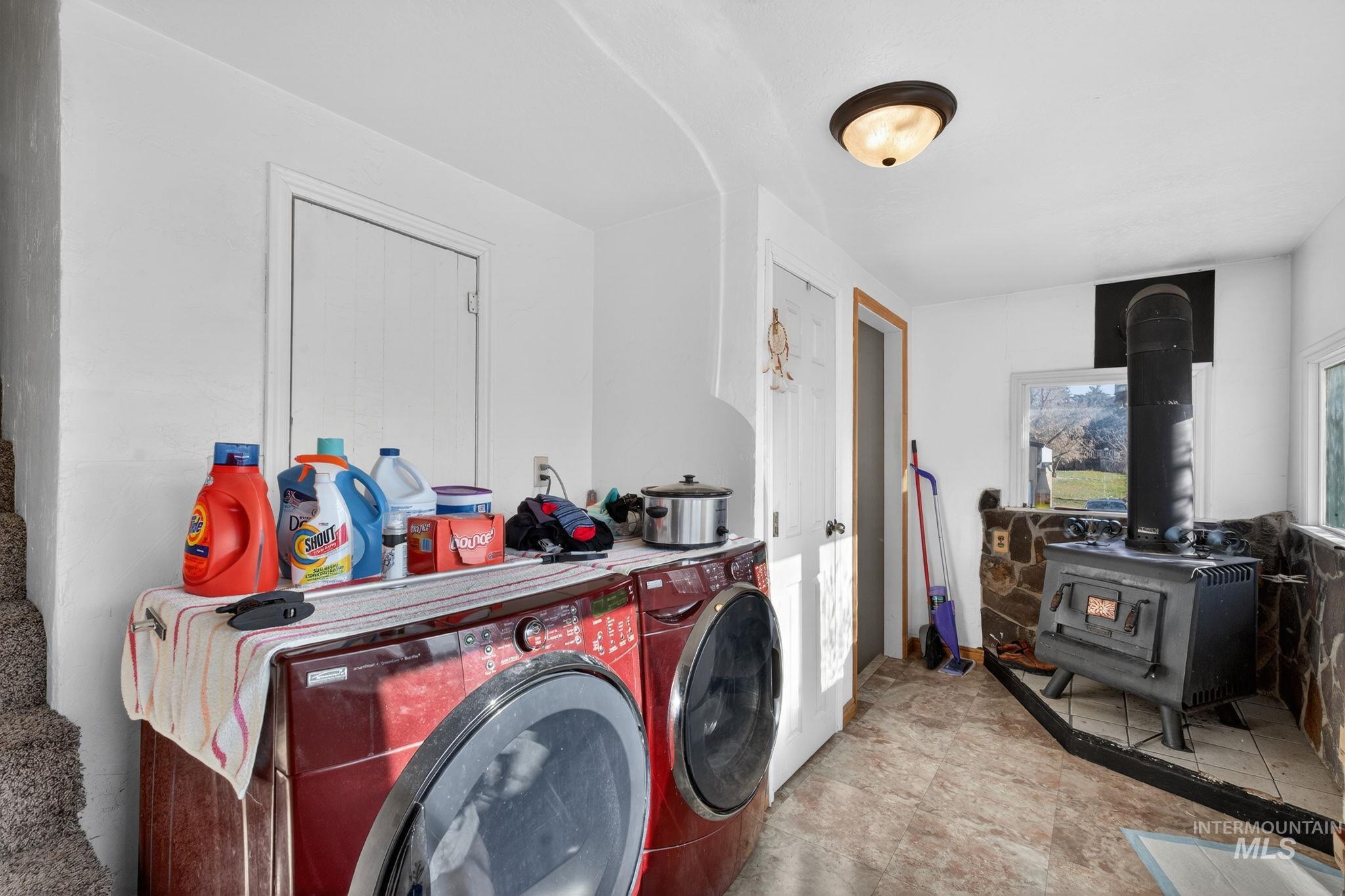 49 South 4th Street West Preston, ID 83263 - Photo 17 of 48 Laundry area featuring a wood stove, washing machine and clothes dryer, and stone finish flooring