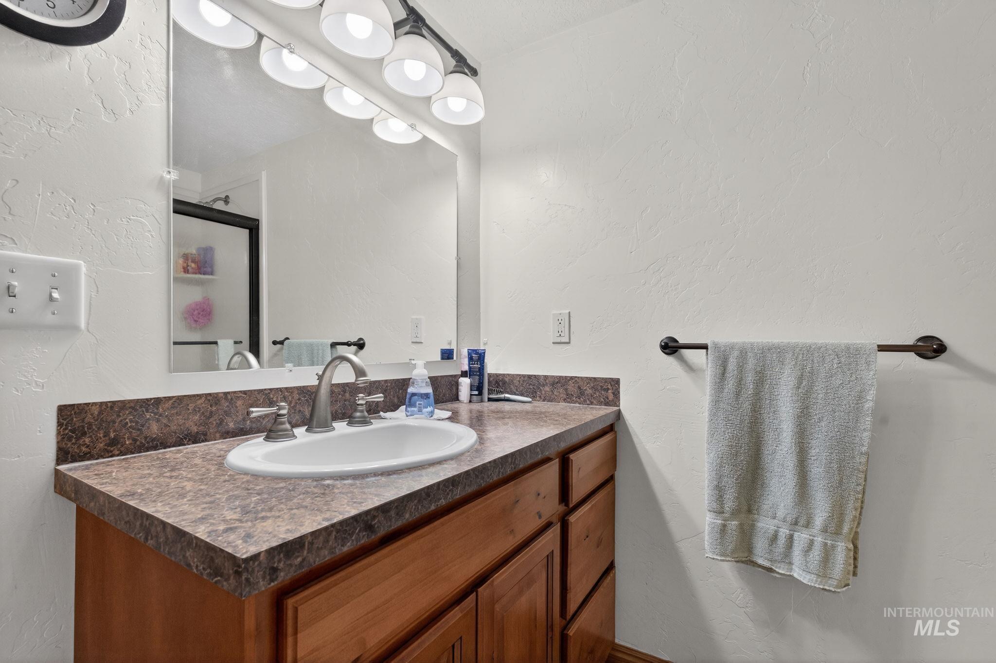 49 South 4th Street West Preston, ID 83263 - Photo 18 of 48 Full bath featuring a textured wall, a shower stall, and vanity